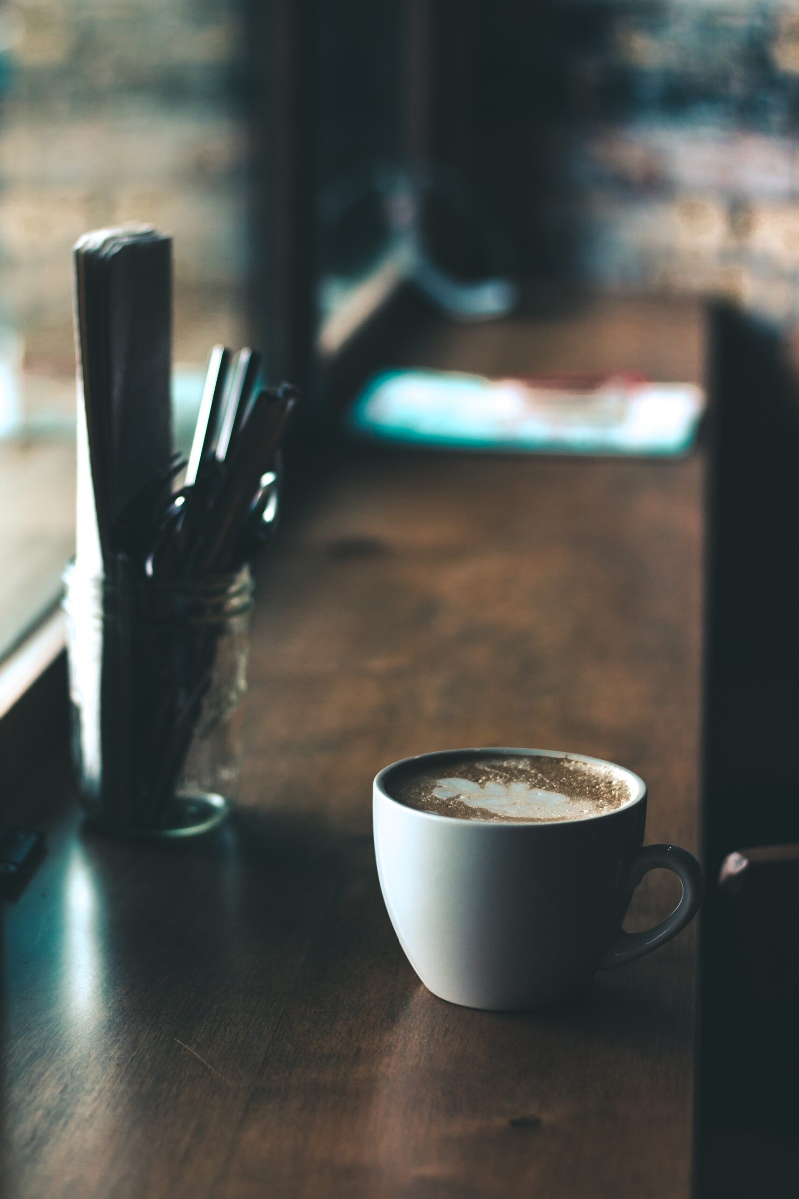white ceramic coffee mug on brown wooden tabletop